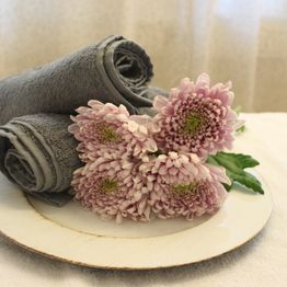 Handdukar och rosa blommor på massagebänk